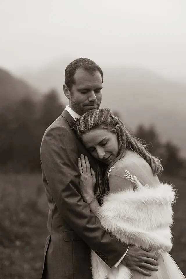 Black and white portrait of a couple embracing in the mountains